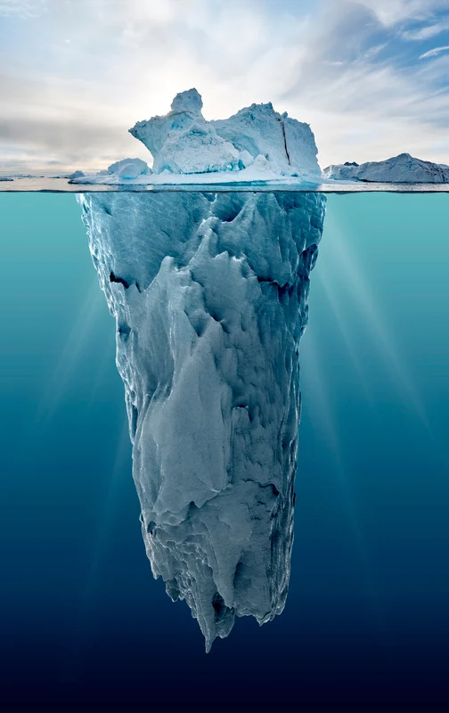 A tall iceberg revealing the much larger structure beneath the waterline